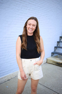 off white denim shorts with a black cable knit tank top