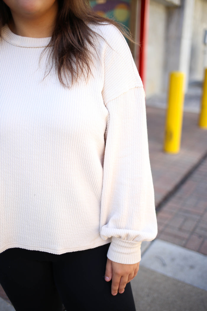 detail view of the ivory solid crewneck long sleeve top