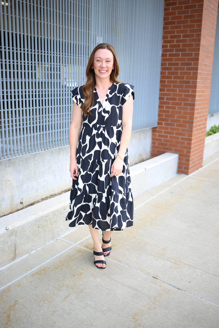 Black and white printed dress with v-neckline and tiered midi length hemline