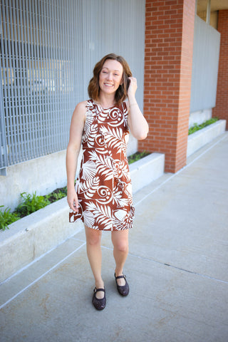 brown and white print sleeveless dress with bow accents
