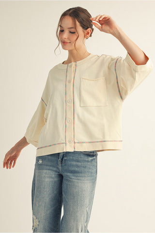 womens wearing a cream relaxed fit cardigan with bright stitch details 