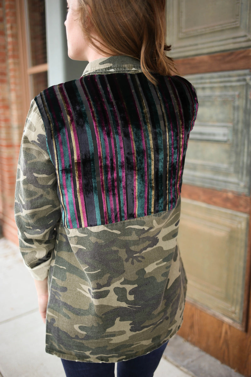 Back detail of a camo jacket with blue, pink, and pink shoulder panel detail.